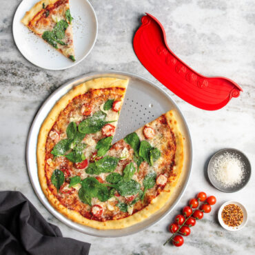 overhead of nordic ware perforated 16" pizza crisper with rock the boat pizza cutter