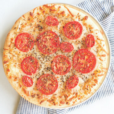 Round aluminum pizza crisper pan with perforated bottom, natural silver finish, showing airflow holes for crispy crusts