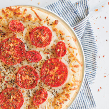 Round aluminum pizza crisper pan with perforated bottom, natural silver finish, showing airflow holes for crispy crusts