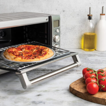 freshly baked pizza resting on hot air crisper and toaster oven rack