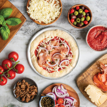 unbaked pizza with ingredients on hot air pizza crisper
