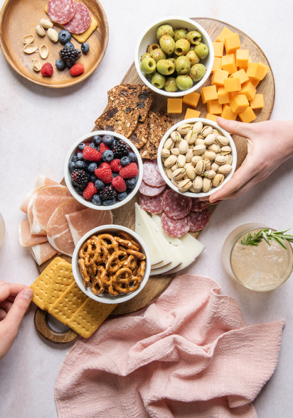 Image of a charcuterie board with Nordic Ware's mini white bowls filled with nuts, olives, snacks, and more.