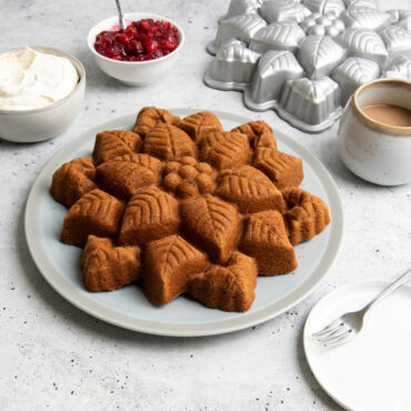 nordic ware cast aluminum poinsettia pull apart pan and plated cake on countertop with silverware and warm beverages