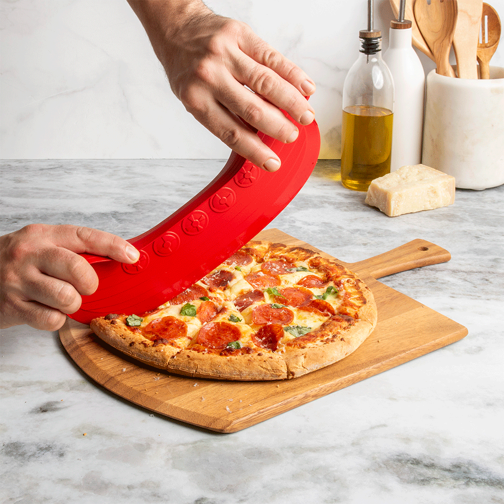 Moving GIF of rock the boat pizza cutter being used to cut pizza on kitchen surface